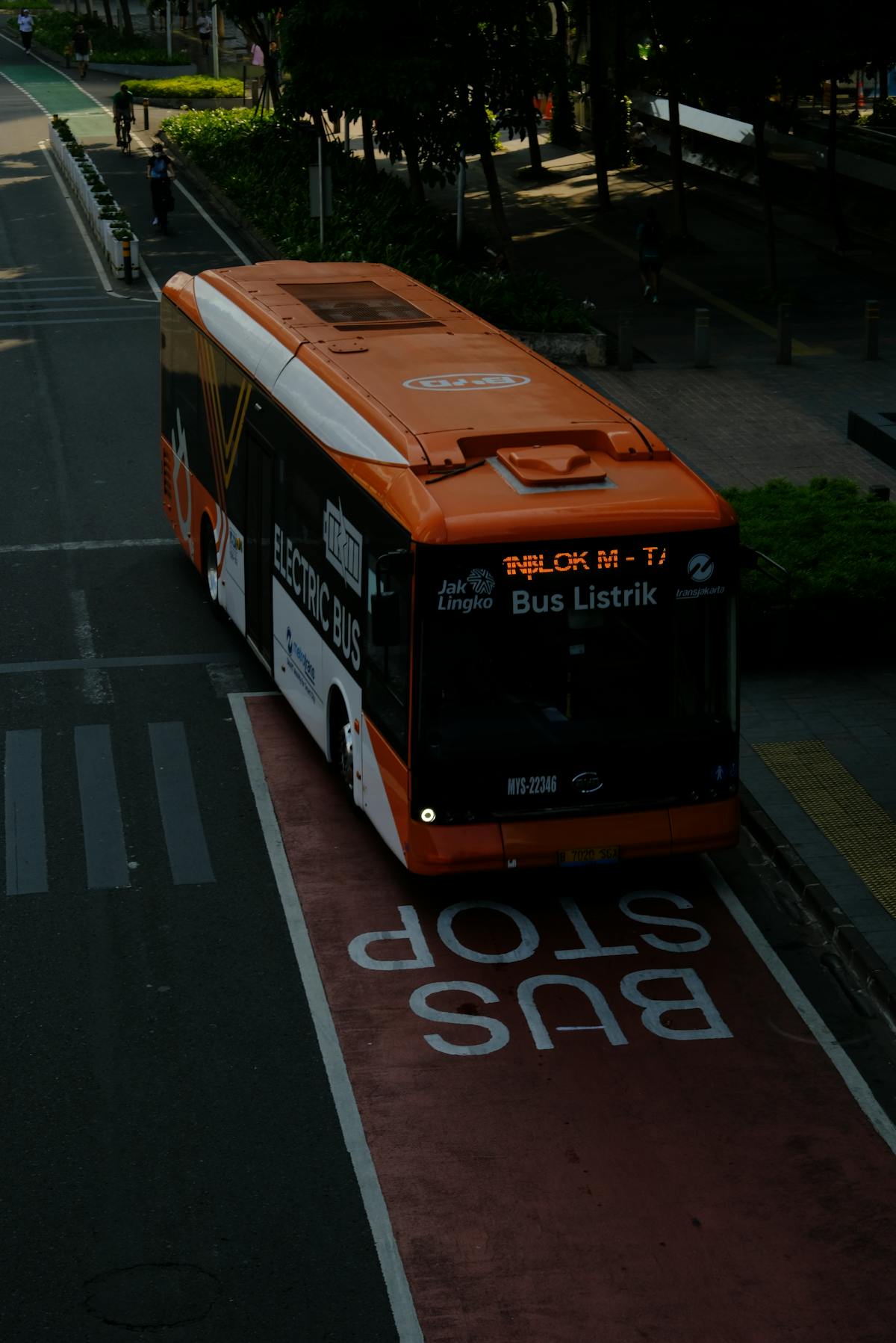 Bus électrique orange circulant sur un couloir de bus dédié en ville